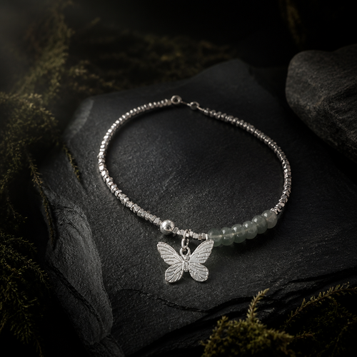 Butterfly pendant with dark green stone and silver cube beads on mossed slate