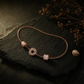 Rose-gold bracelet with a Roman numeral plaque on dark wood