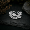 Silver rose ring with a clear zircon among dried botanicals on slate