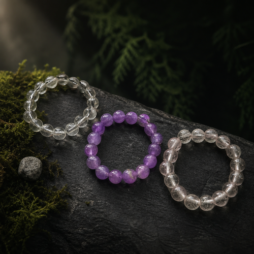 Clear, pale grey and soft pink crystal bead rings on mossed stone