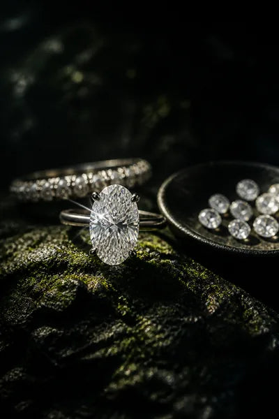 A laboratory-grown diamond ring photographed on a dark base, lit to show its brilliance