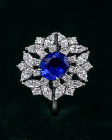 A finished sapphire ring photographed in macro, its stone set upright and catching the light
